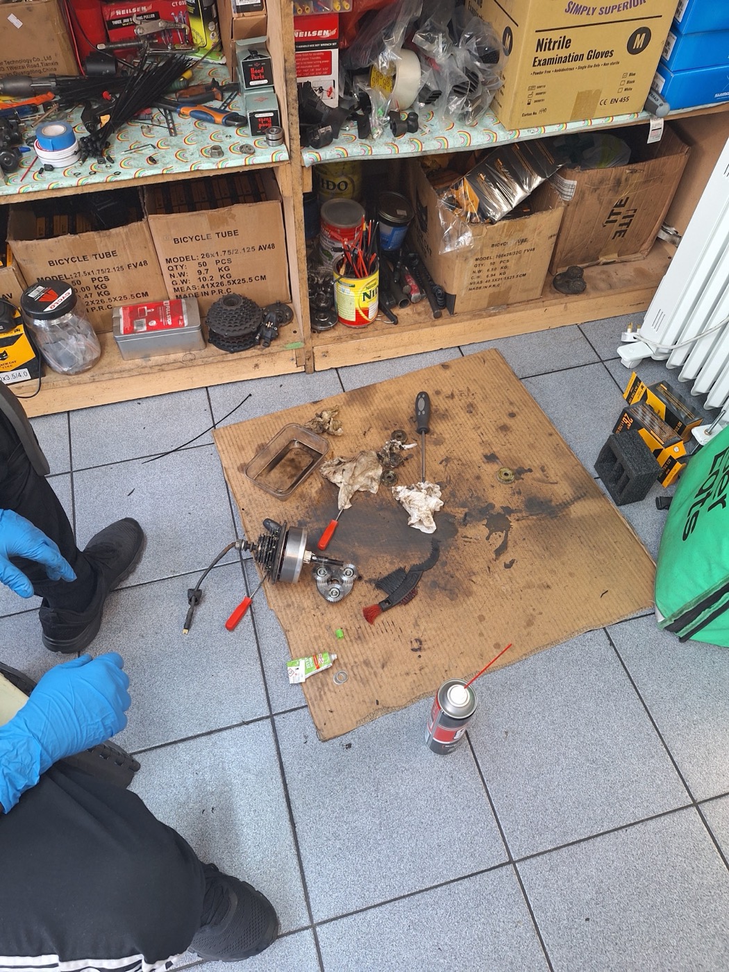 The workshop at Bethnal Green Cycles with tools, boxes of bicycle tubes and a repair in progress.